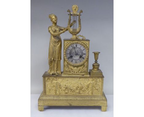 A late 19thC Continental gilded metal cased mantel clock, ornamented with a standing classical maiden, a lyre and floral wrea