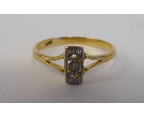 A yellow metal ring, set with five diamonds, arranged on a central bar&nbsp; stamped 18ct&nbsp; 