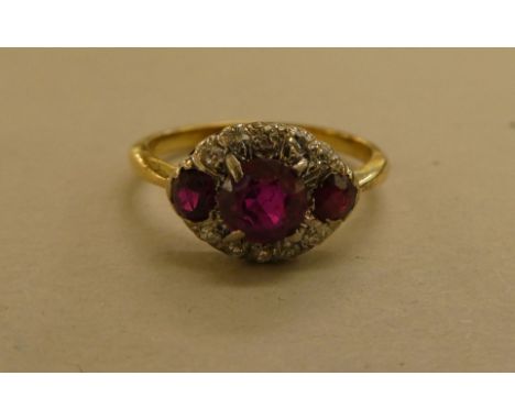 A yellow metal ring, set with diamonds and red stones 