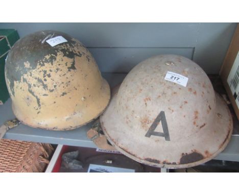 An Air Raid Warden's tin hat and a US Army hat.