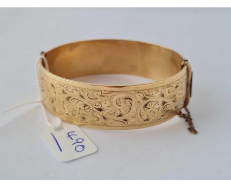 A rolled gold engraved hinged bangle 