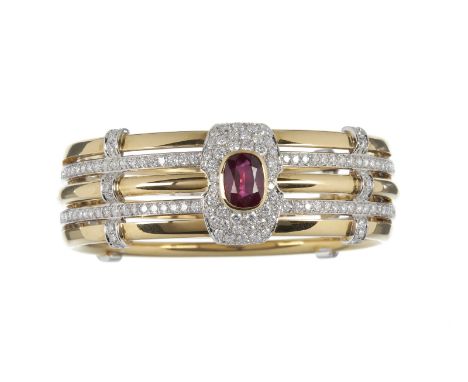A ruby and diamond bangle, the five hoop hinged bangle centrally set with a mixed cut ruby above a pave set diamond ground an