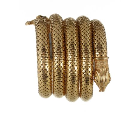 An mid 20th century gold coloured serpent bracelet, the flexible four coiled serpent of snakeskin effect with ruby eyes in th