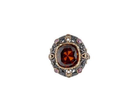 A citrine and ruby ring, the cushion shaped mixed cut citrine rub over set in a pierced mount with circular cut ruby accents 