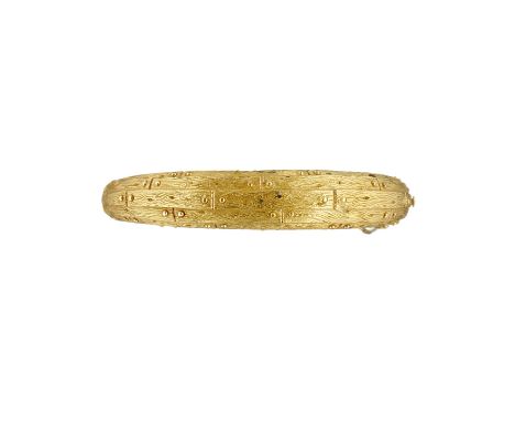 A 1960s French gold coloured hinged bangle, the textured tapered top with a snap clasp on a polished bangle base, the clasp w