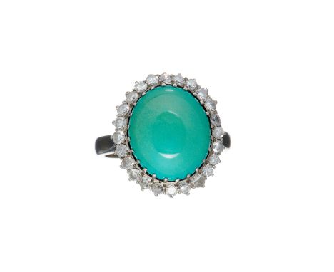A turquoise and diamond cluster ring, the large oval turquoise cabochon claw set within a surround of eight cut diamonds, sta