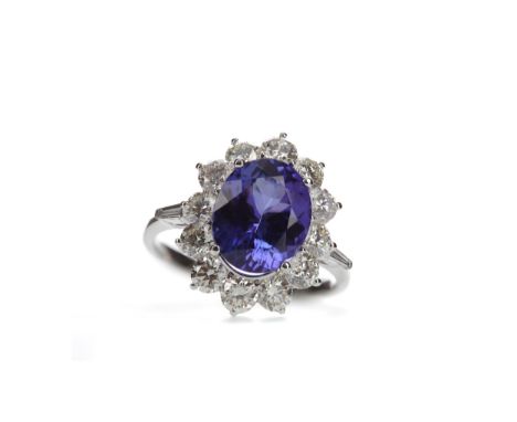 TANZANITE AND DIAMOND RING, set with an oval tanzanite of approximately 4.22 carats, within a halo of round brilliant cut dia
