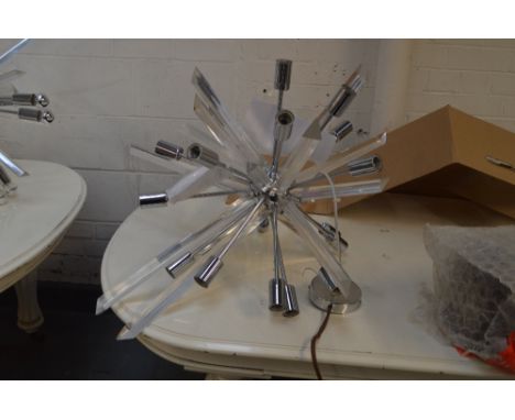 A perspex and chromed ceiling light of abstract form, slightly smaller.