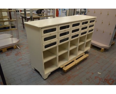 A painted shop fitting with upper section comprising fifteen drawers above ten pigeon holes raised on bracket feet, width 201