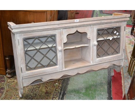 A pine wall mounted cabinet with glazed leaded light.