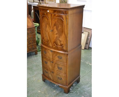 A mahogany and walnut reproduction bow front cocktail cabinet, two panel doors to top, cupboard to base with three faux drawe