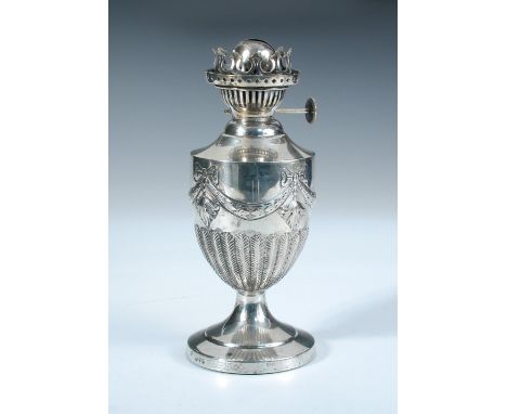 A late Victorian silver table oil lamp, by Edward Hutton, London 1890, the vase shaped body part feather fluted below swags, 