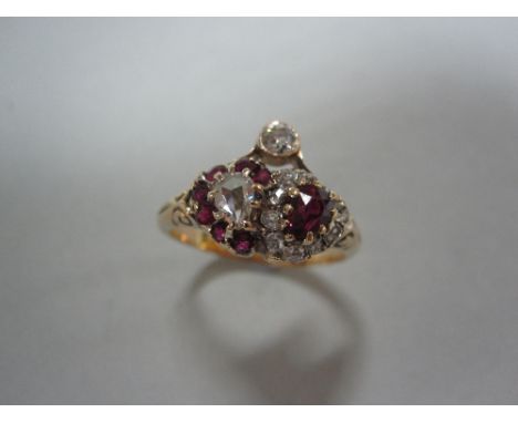 A ruby and diamond double heart ring, designed as overlapping hearts of opposing colours, with a pear cut ruby in a border of