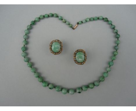 A pair of jadeite jade earstuds and a matched jade bead necklace, the earstuds each with a mottled green jade cabochon within