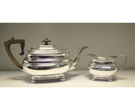 A Silver teapot and milk jug, by Garrard and Co, Sheffield 1954, the teapot of compressed rectangular form below a gadrooned 