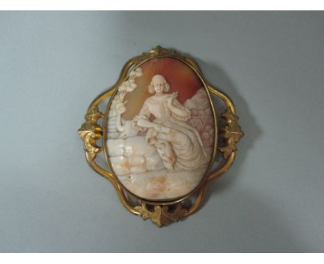 A shell cameo depicting a late 17th century lady in a rustic landscape, the large oval portrait format cameo showing a seated