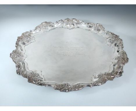 A large Edwardian silver salver, by Mappin & Webb, Sheffield 1909, circular with shaped fruiting vine border and raised on th