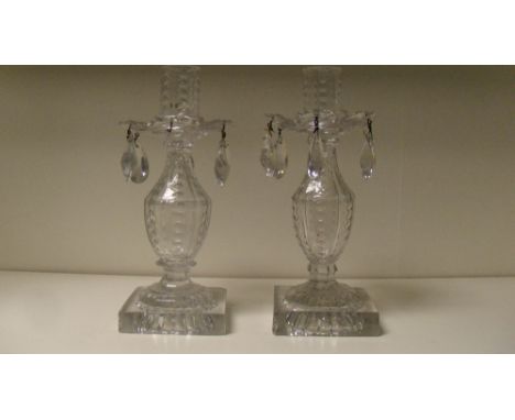 A pair of cut glass candlesticks with detachable lustres, the cut baluster bodies supported on square lemon squeezer feet, ea