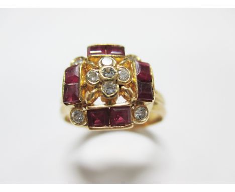 A modern ruby and diamond cluster ring, set to the centre with a quatrefoil of five round brilliant cut diamonds to a pierced