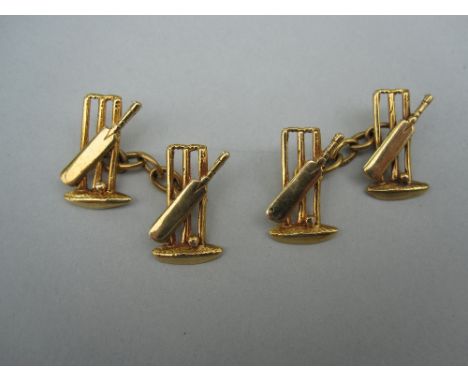 A pair of cricketer's double-ended cufflinks, each end design as a cricket bat and ball against the wicket stumps and bales s