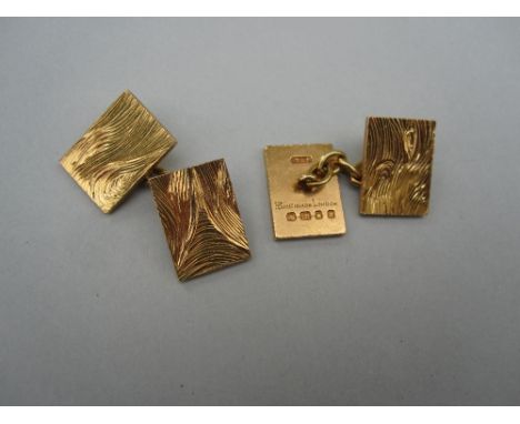 A pair of 18ct gold double-ended cufflinks by Boucheron, each flat rectangular plaque with an abstract pattern of hand-gouged