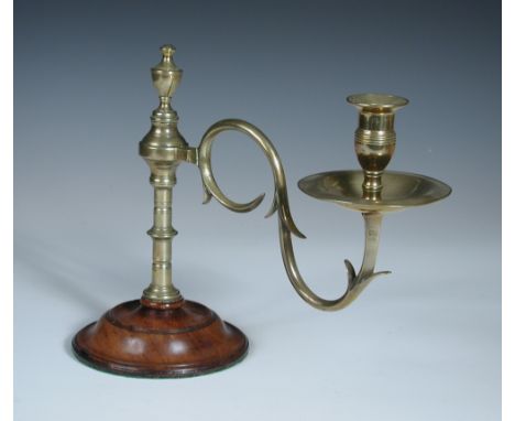 A late 18th century brass and mahogany candlestick, the turned brass column with rotating candle arm supported on a turned ci