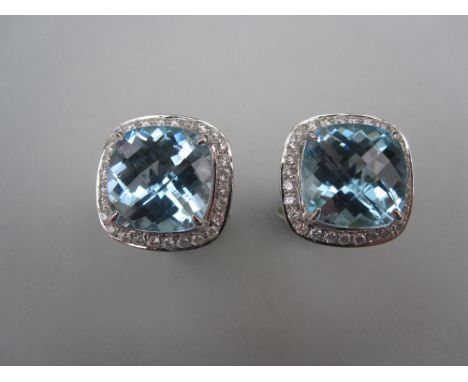A pair of blue topaz and diamond cufflinks, each with a harlequin faceted cushion cut topaz above a border of round brilliant