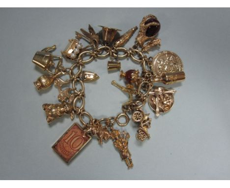 A 9ct gold charm bracelet with twenty-one mostly hallmarked charms, the antique fancy link bracelet suspending some unusual c
