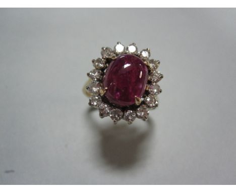 A treated ruby cabochon and diamond cluster ring, the cushion cabochon fracture-filled ruby claw set in a petal edge border o