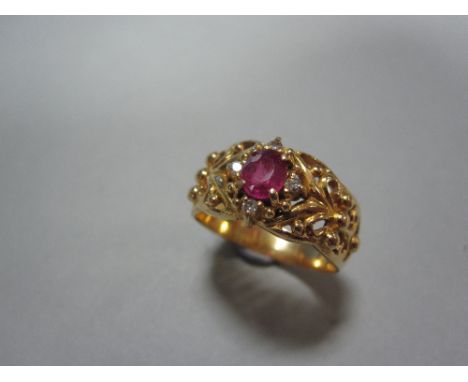 A Sri Lankan ruby and diamond ring, the oval cut ruby with round brilliant cut diamond highlights at the cardinal points, set