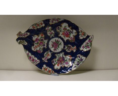 A Worcester blue scale dish, the leaf shape painted with gilt framed mirror shaped reserves of flowers, pseudo Chinese seal m