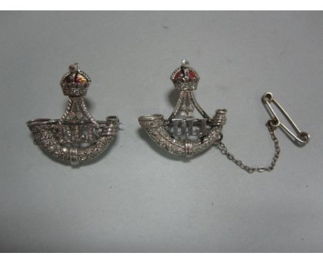 Two regimental diamond set brooches for the Durham Light Infantry , both with crown surmount with red enamel lining and singl