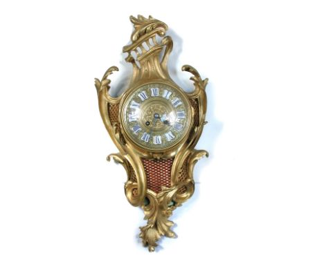 A French ormolu cartel clock, circa 1900, the scroll mounted case with gilt dial having inset enamel numerals, and patterned 