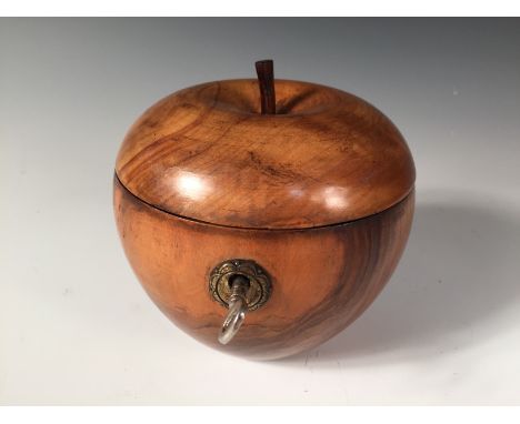 A turned fruitwood apple shaped tea caddy, with a circular brass escutcheon, the hinged top with a stalk 12cm (5in)