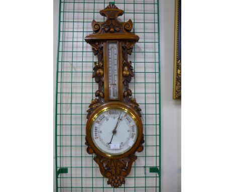 An early 20th Century carved oak aneroid barometer, 88cms h 