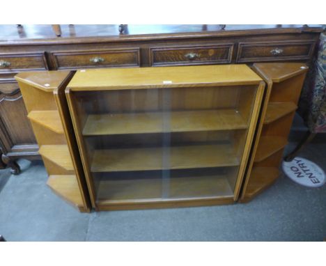 A light oak bookcase and pair of matching corner cabinets 