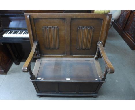 An oak linenfold monk's bench 