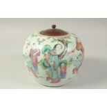 A 19TH CENTURY CHINESE FAMILLE ROSE PORCELAIN JAR AND WOODEN COVER, painted with a joyous scene of