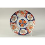 A JAPANESE IMARI PORCELAIN CHARGER, painted with panels of flora, 31.5cm diameter.