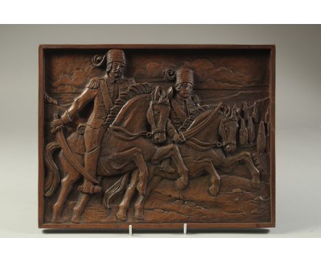 A FINE CARVED WOODEN PANEL, depicting two Ottoman soldiers on horseback, 35cm x 27cm.