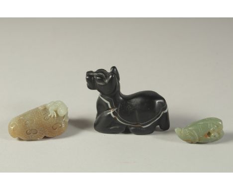TWO FINELY CARVED JADE PIECES, together with a black agate reclining animal, (3).
