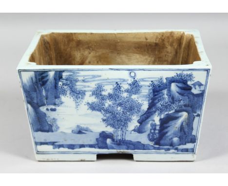 A CHINESE BLUE AND WHITE PORCELAIN RECTANGULAR PLANTER, each side depicting landscape scenes with a river, on four bracket fe