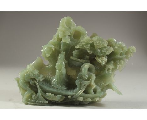 A LARGE CHINESE CARVED JADE GROUP DEPICTING FIGURES ON A BOAT, with a dragon and back-panel of trees and buildings, 26cm wide