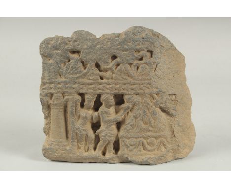 A RARE GANDHARA CARVED GREY SCHIST STONE TILE FRAGMENT, depicting two men around a ceremonial fire, 17cm x 15cm.