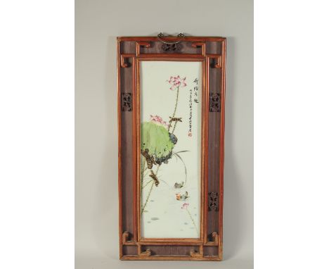 A CHINESE FAMILLE ROSE PORCELAIN PLAQUE, inset within a wooden frame, panel 56cm x 19cm.