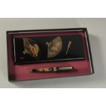 A JAPANESE GILT AND BLACK LACQUER BOX AND PEN SET, boxed.