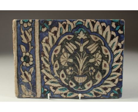 A FINE 17TH CENTURY OTTOMAN DAMASCUS GLAZED POTTERY TILE, with a large lotus flower, tulips and carnations within, 28cm x 20c