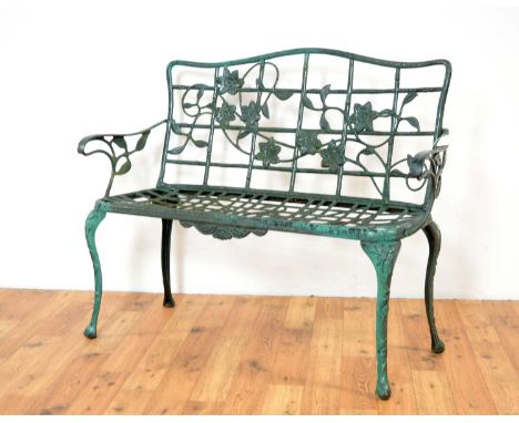 A 20th Century metal garden bench painted in a dark green colourway, the pierced backrest with foliate detailing, flanked by 