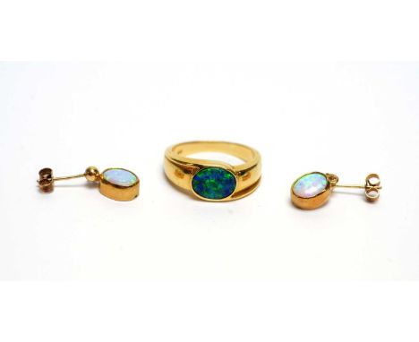 An opal ring, possibly a doublet, in yellow gold shank stamped '585 14K', size N 1/2, 4.6g; together with a pair of opal drop