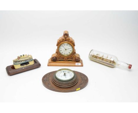 An aneroid wall barometer, mounted to an oak wall plaque with carved floral decoration, 27cms wide; a walnut mantel clock by 